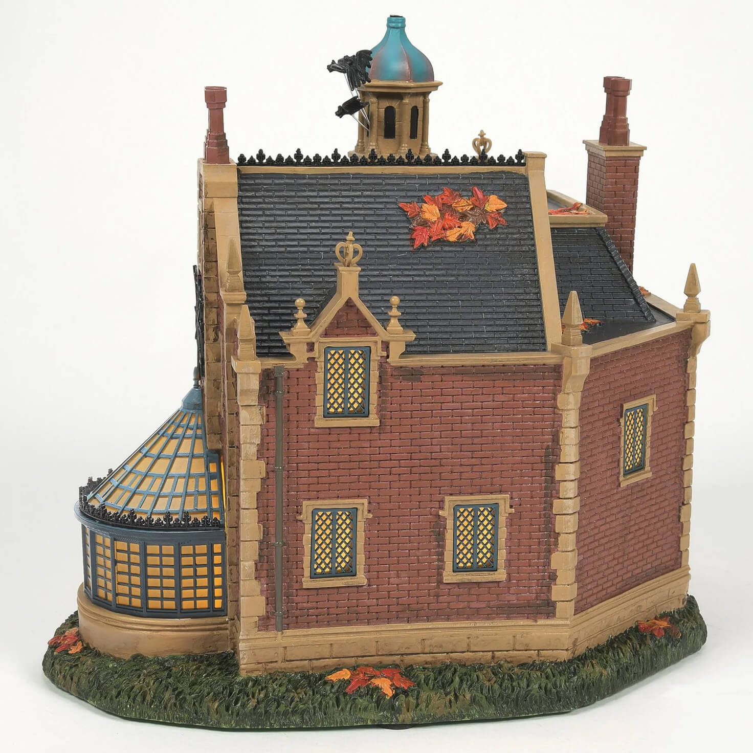 Red brick victorian style disney haunted mansion model with black roof blue domed tower and autumn leaves on roof