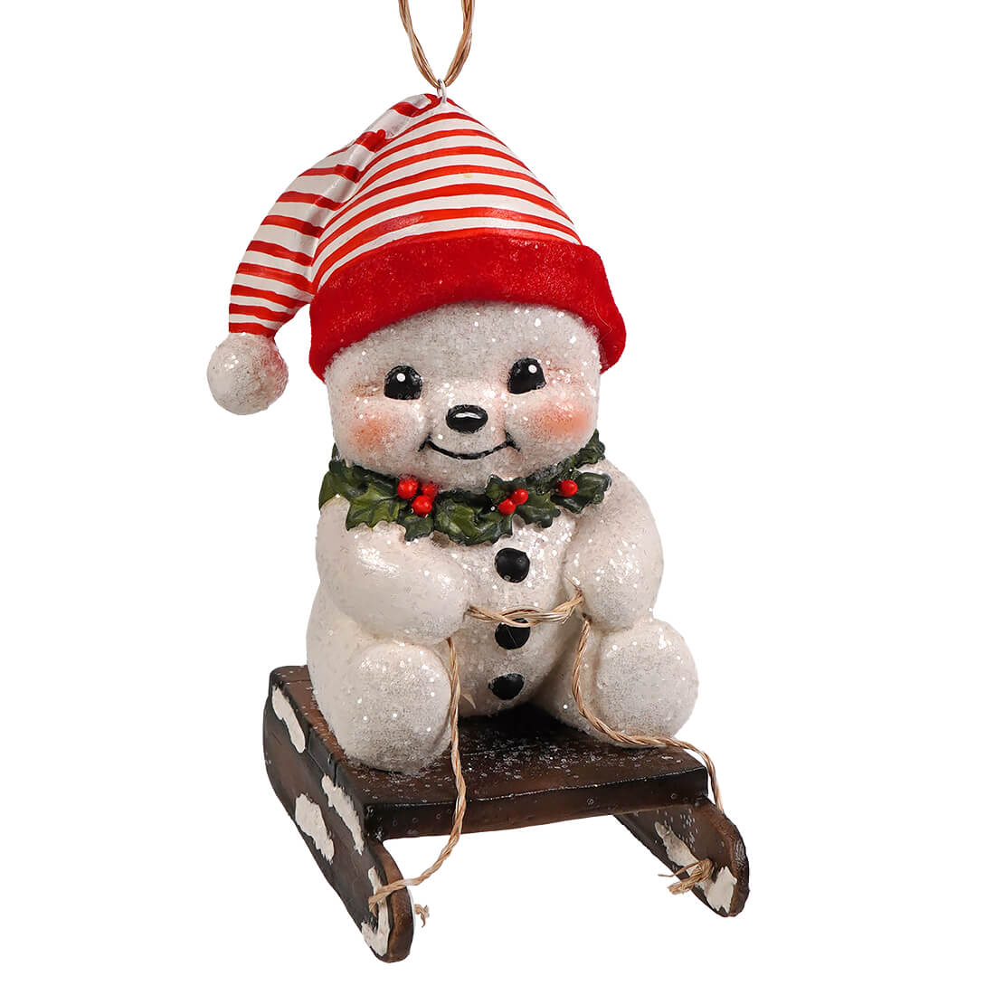 A festive white glittery snowman ornament with striped hat on wooden sled with holly from bethany lowe design snowman ornaments