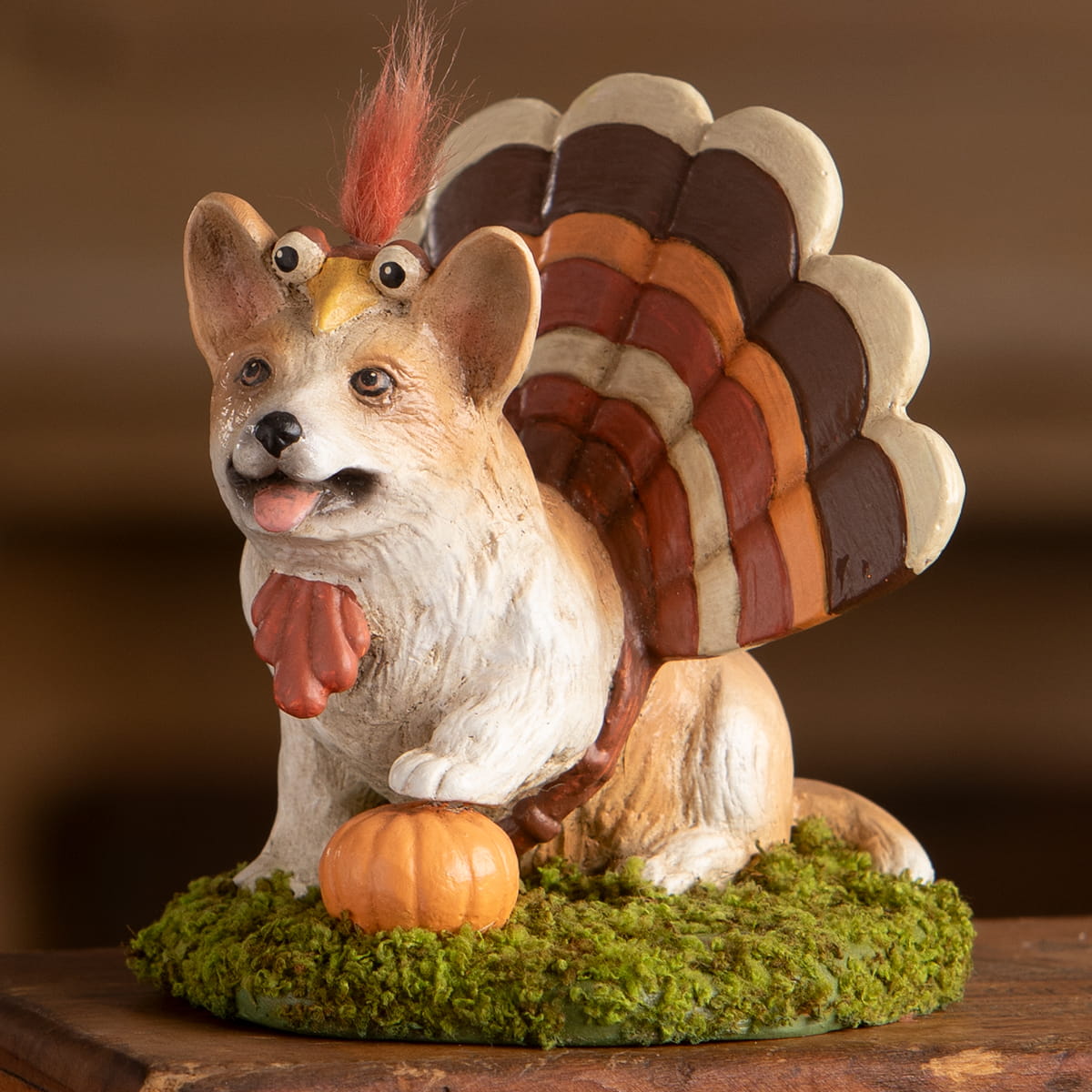 A whimsical ceramic figurine of tommy the corgi dressed as a turkey with brown orange wings by bethany lowe