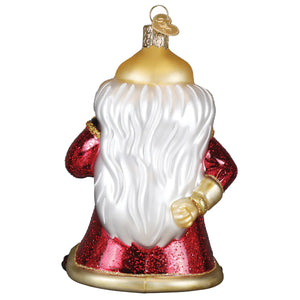A glossy red and gold glass dungeons and dragons dungeon master ornament with glittery coat and white beard for tabletop decor