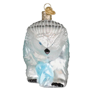 A translucent silver glass dungeons and dragons snowy owlbear ornament holding a light blue crystal tabletop decor