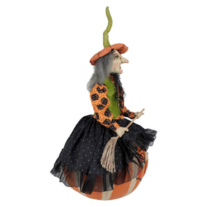 Eartha halloween witch figurine with gray hair orange hat and black polka dot skirt on a carved pumpkin from joe spencer’s gathered