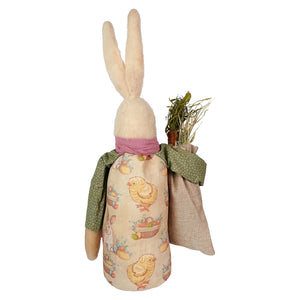 A plush easter attire white bunny holding sack dressed in a beige dress with yellow chicks and green apron