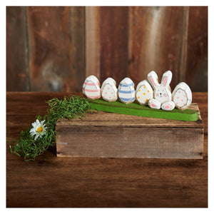 A charming wooden easter bunny tabletop decor with five painted eggs on a green grassy base perfect for spring display