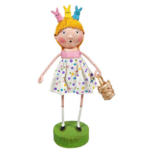Whimsical doll figurine wearing a polka dot dress, holding a basket, with three bunny decorations perched on its yellow hair.