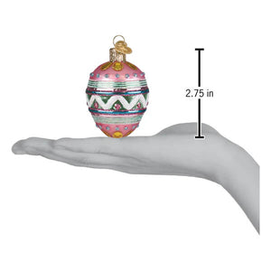 A pink glass christmas ornament hand-painted with green white and gold geometric patterns with a golden cap easter egg ornament