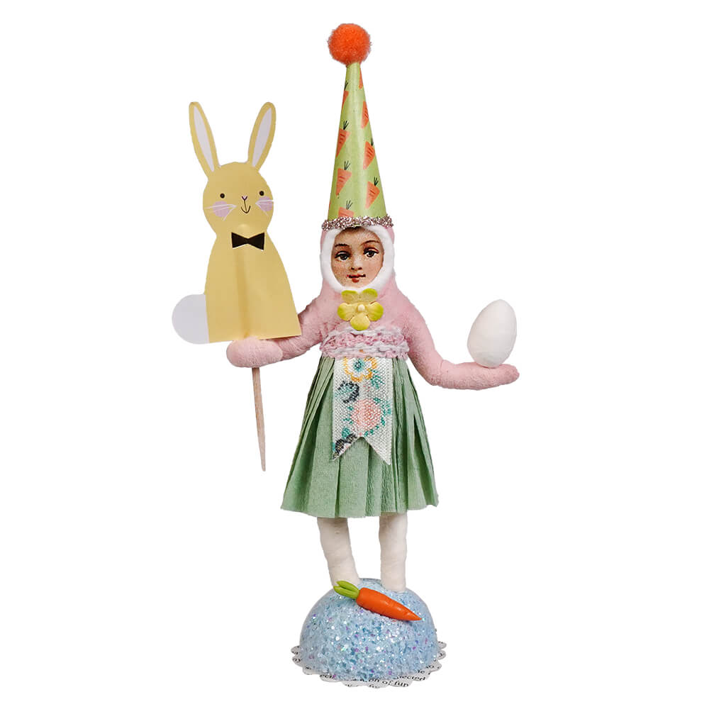 Handcrafted folk art easter girl figurine with yellow bunny pick wearing carrot hat holding paper bunny and white egg
