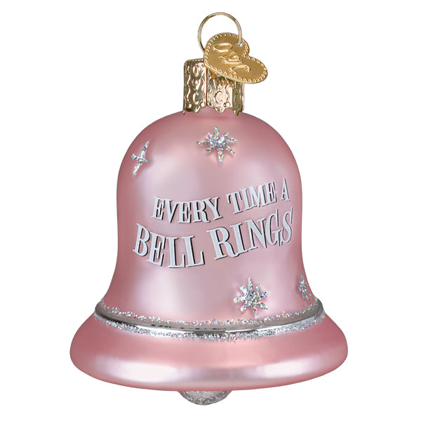 A pink glass christmas bell rings ornament with silver glitter and white engraved phrase every time a bell rings