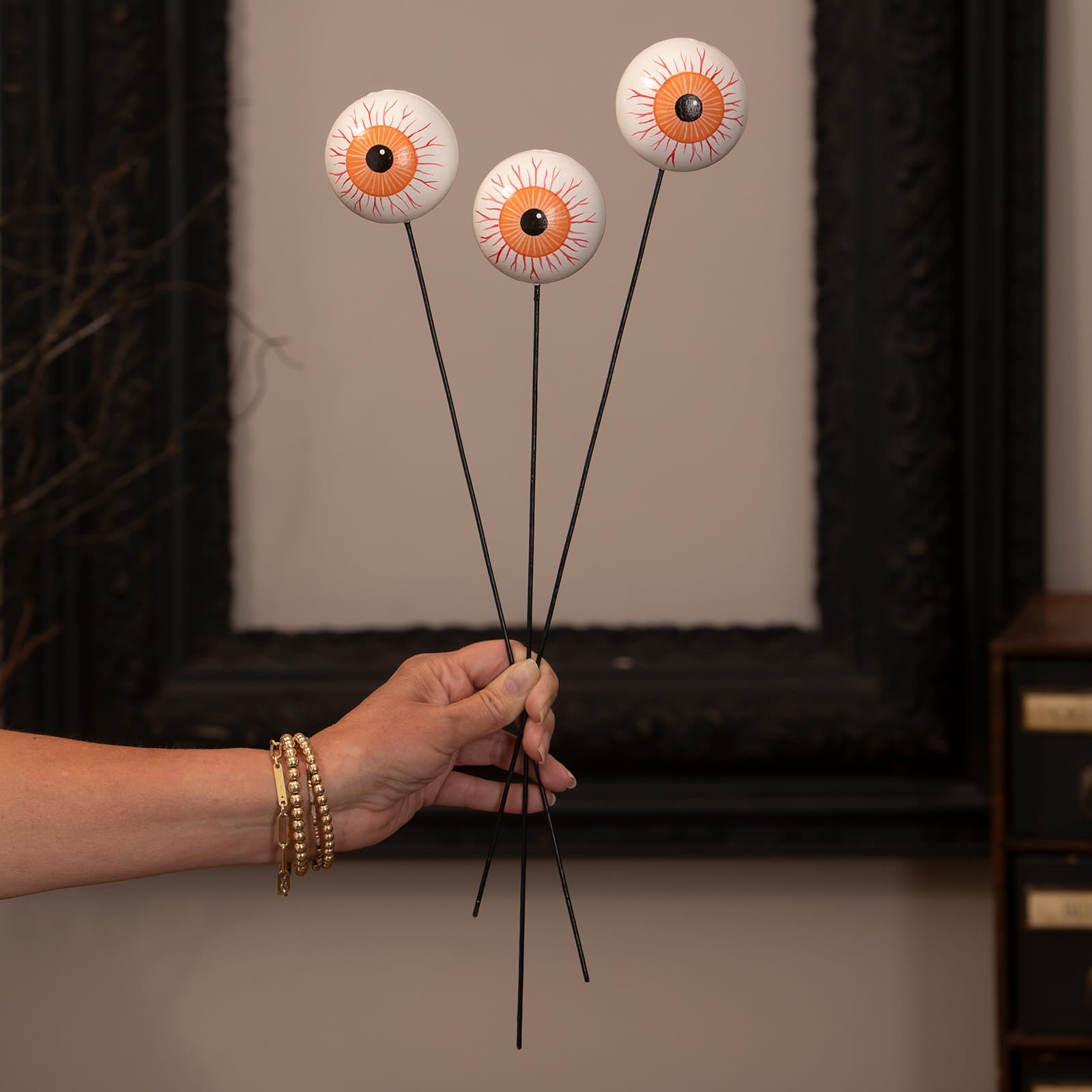 Three white ceramic eyeball picks with orange black details from bethany lowe designs halloween garlands wreaths & picks