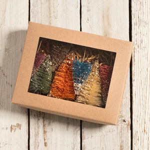 A set of colorful glittery fall bottle brush trees in a kraft paper box perfect for village trees decor
