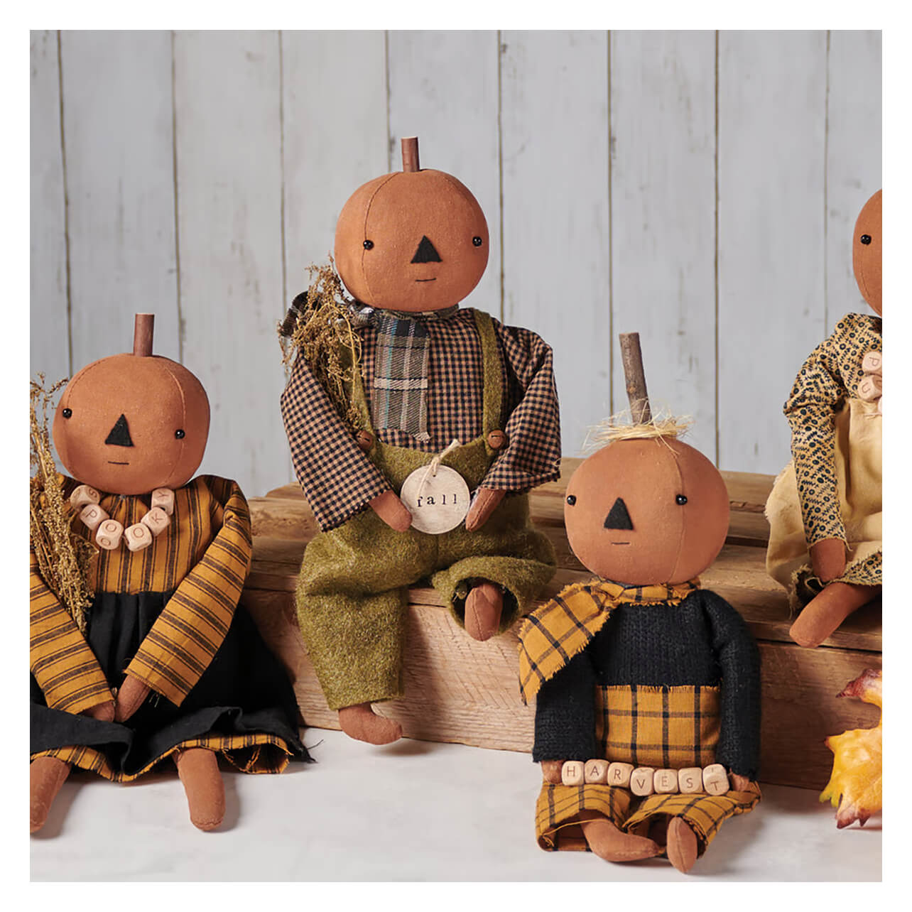 Handcrafted freddy pumpkin doll with stitched face wearing plaid earthy brown green and yellow from kathy fall collection