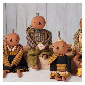Handcrafted freddy pumpkin doll with stitched face wearing plaid earthy brown green and yellow from kathy fall collection
