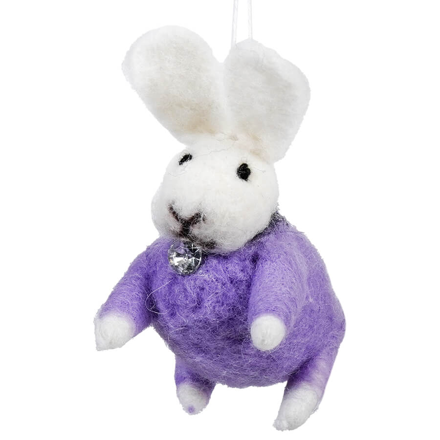White felt bunny wearing a purple sweater with a sparkly brooch.