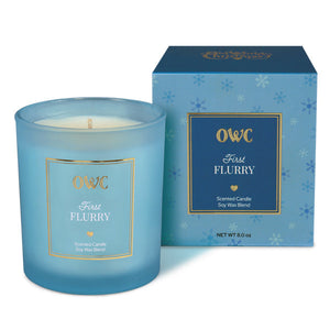 A translucent light blue glass candle jar with white soy wax blend labeled first flurry by owc perfect for a creative co-op candle set