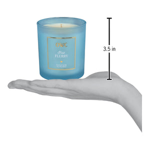 A translucent light blue glass soy wax candle jar with a gold-trimmed label first flurry from creative co-op