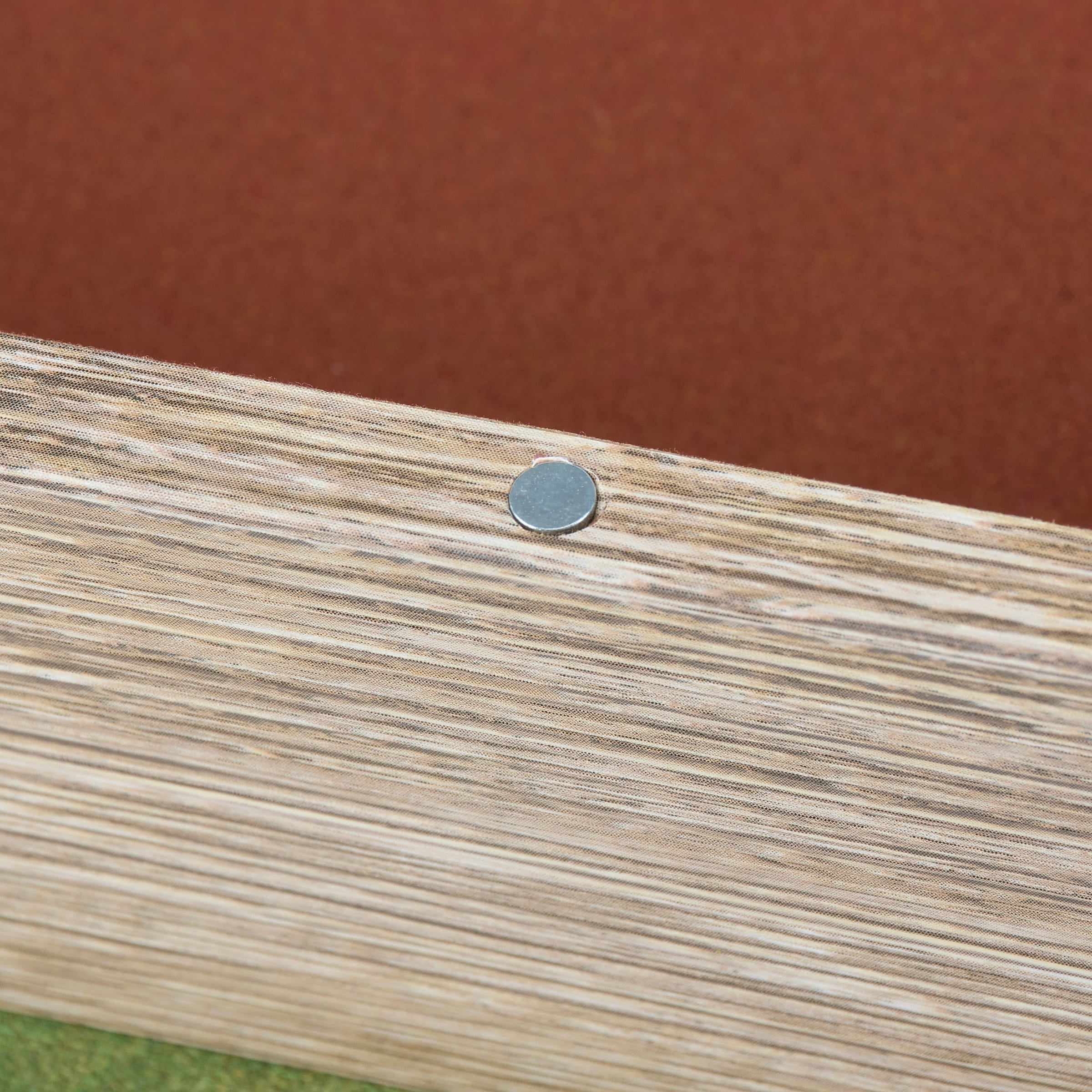 A small round metallic nail on the light wood edge of the flakes of wisdom book box set by dan dipaolo Christmas box sign