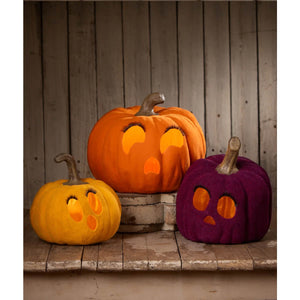 Three illuminated halloween pumpkins with orange and purple flocked plush exteriors by bethany lowe design