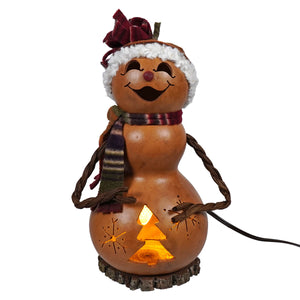 A lighted small tall brown snowman girl gourd from meadowbrooke gourds glowing warmly with carved tree and star design