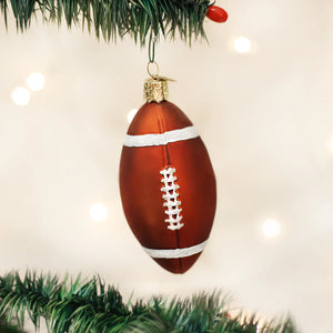 Glossy brown glass football ornament with white glittery laces and stripes hanging from christmas tree branch figural decor