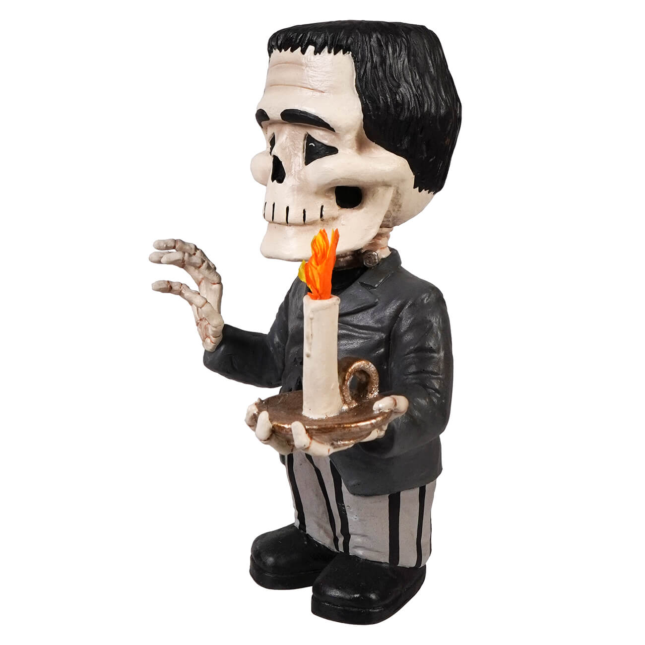 A black-and-white franken skelly figurine holding a lit candle on a tray dressed in a dark suit and striped pants