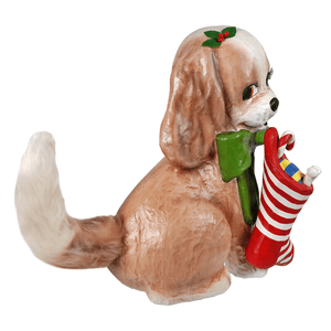 A bethany lowe design frankie puppy figurine in beige and white holding a red and white christmas stocking with holly
