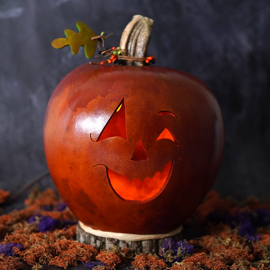 A large lighted jack o lantern gourd by meadowbrooke gourds artisans carved as a glowing orange pumpkin lantern