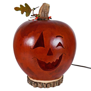 Carved large lighted jack o lantern gourd by meadowbrooke gourds artisans glowing in warm orange light