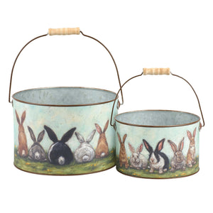 Set of two rustic metal easter buckets with wooden handles and painted designs on a light blue background friends bucket set