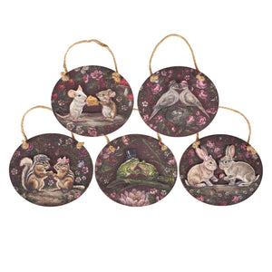 Set of five round wooden valentine’s day ornaments with whimsical animal couples on dark floral background