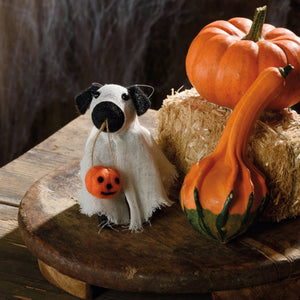 White fabric ghost dog critter with black ears and nose holding orange pumpkin from kathys halloween collection