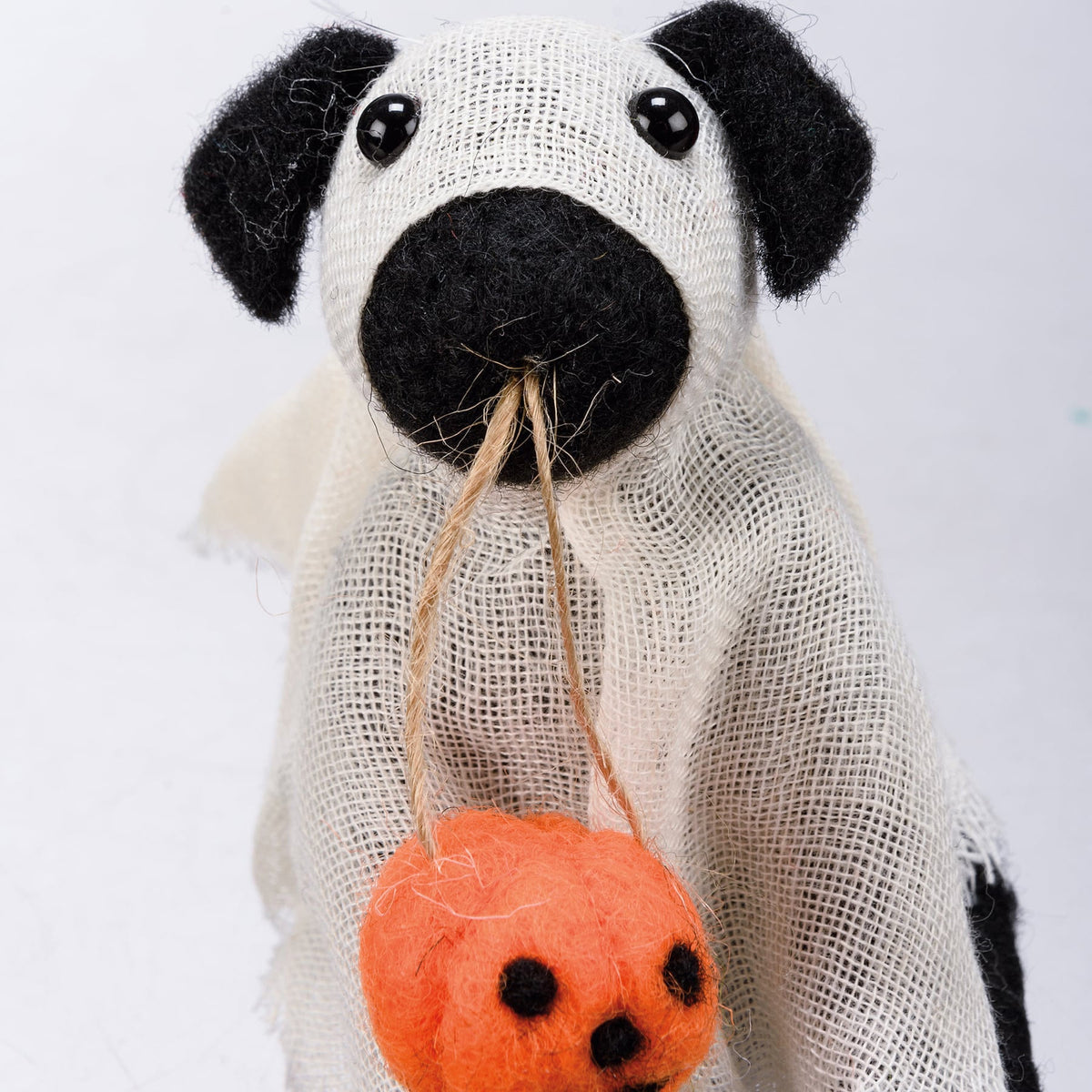 Ghost dog critter black and white felt dog ornament with mesh body holding orange wool pumpkin bag from kathys halloween collection