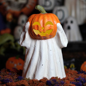 A white ghost jack o lantern figurine holding an orange carved pumpkin perfect for halloween decor