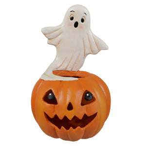 A cheerful white ghost figure with black eyes on an orange jack o lantern made of plastic halloween ghost figures decor and ornaments