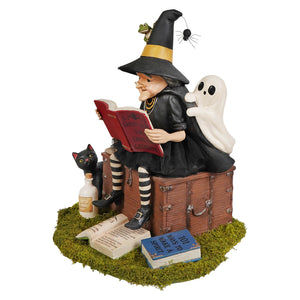 Black witch figurine with striped stockings yellow-trimmed hat ghost cat and books on mossy base halloween witches decor