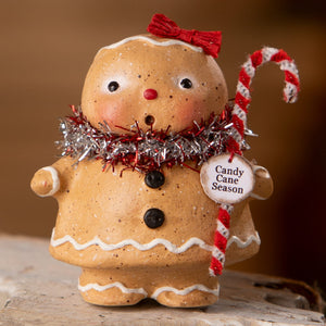 A charming gingerbread girl figurine with white icing and red bow from bethany lowe designs gingerbread decor