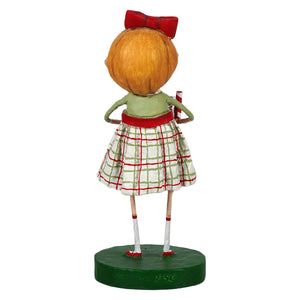 A whimsical lori mitchell figurine of a girl with orange hair and plaid skirt from ginger’s house collection
