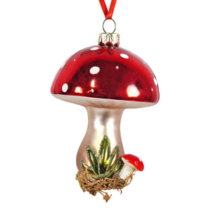 Glossy red and silver glass mushroom ornament with white polka dots and small green plant for lighted decor