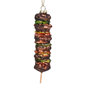Christmas tree ornament shaped like a kebab skewer with meat and vegetables.