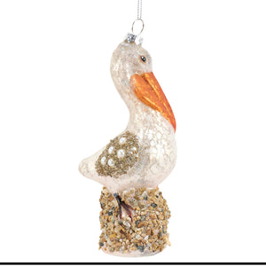 A translucent glass pelican ornament with an orange beak and pearl details, perfect for sea and beach themed ornaments