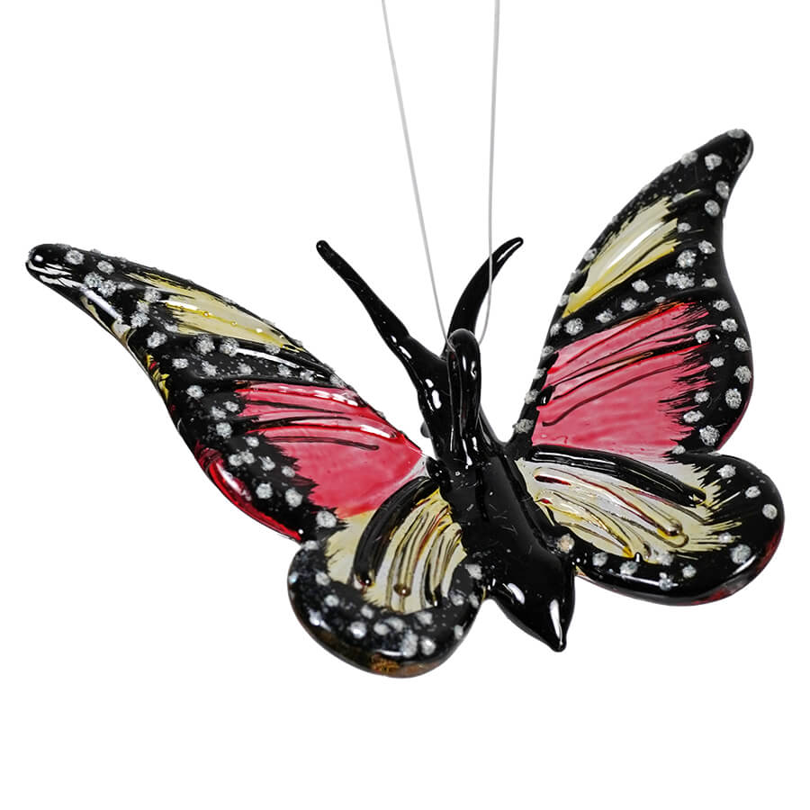 Decorative butterfly ornament with black, pink, cream and white patterned wings.