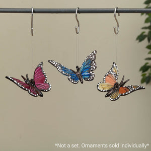 Three colorful butterfly ornaments hanging from hooks.