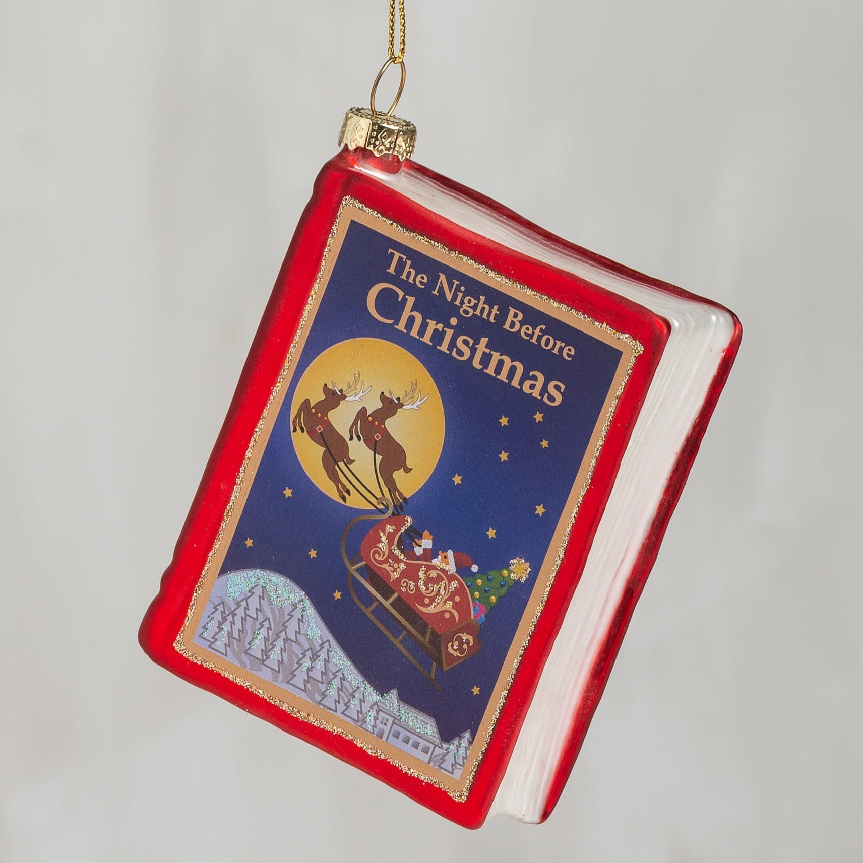 Red glass storybook ornament shaped like a book with classic holiday the night before christmas cover art