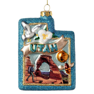 Glass utah state ornament with blue glittery border and detailed desert landscape perfect for travel and location themed ornaments