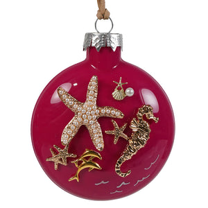 A vibrant pink fuchsia glass ornament with gold seahorse starfish and pearl embellishments perfect for bette day decor