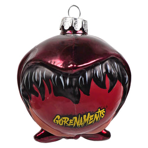 A glossy red witch glass ornament by kurt adler with a menacing black mouth and yellow gorenaments lettering