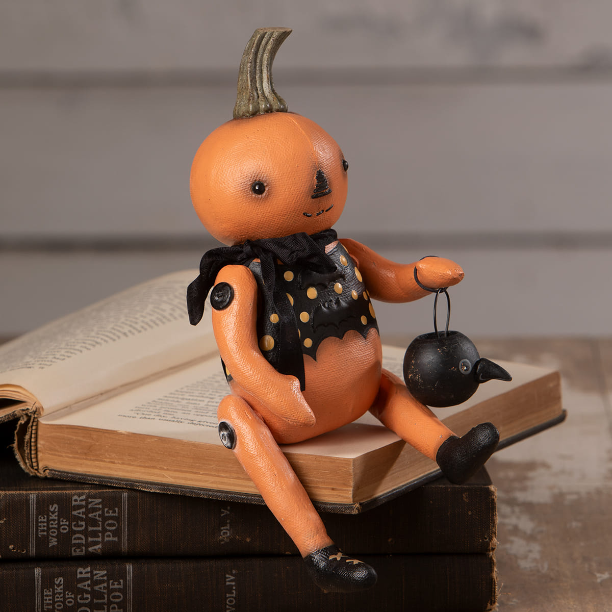 Orange pumpkin sitter doll with black polka-dot vest holding a lantern from bethany lowe halloween figures and dolls