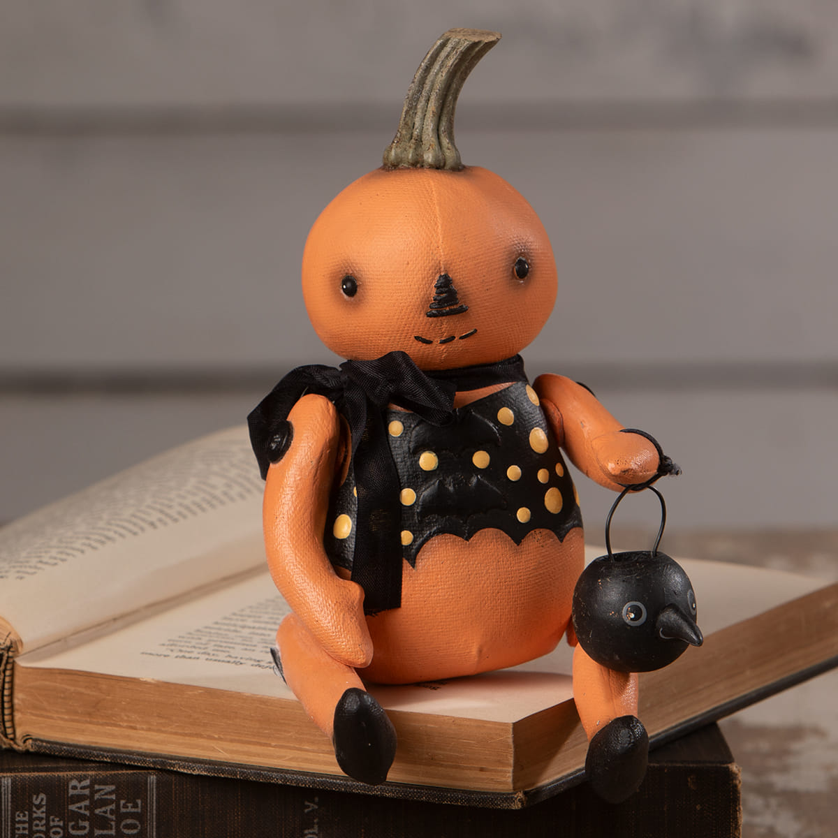 Orange pumpkin sitter figurine wearing a black polka-dot vest holding a small black lantern bethany lowe halloween figures and dolls