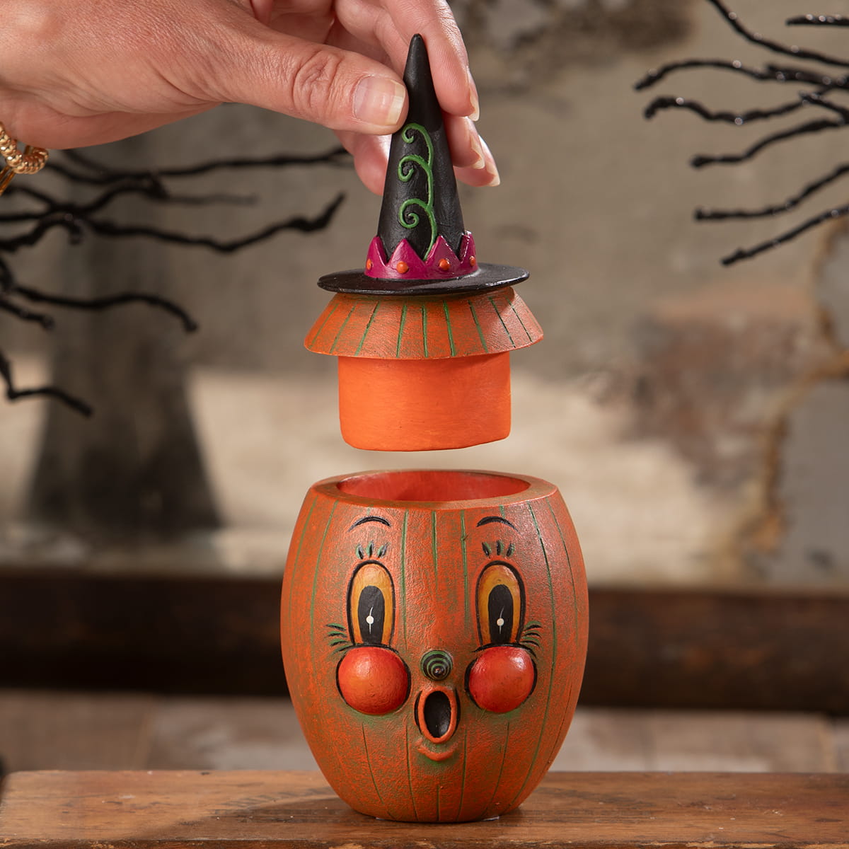 Orange pumpkin-shaped ceramic jar with black witch hat lid green swirls and pink trim gourdy orange-o-ween jar bethany lowe designs