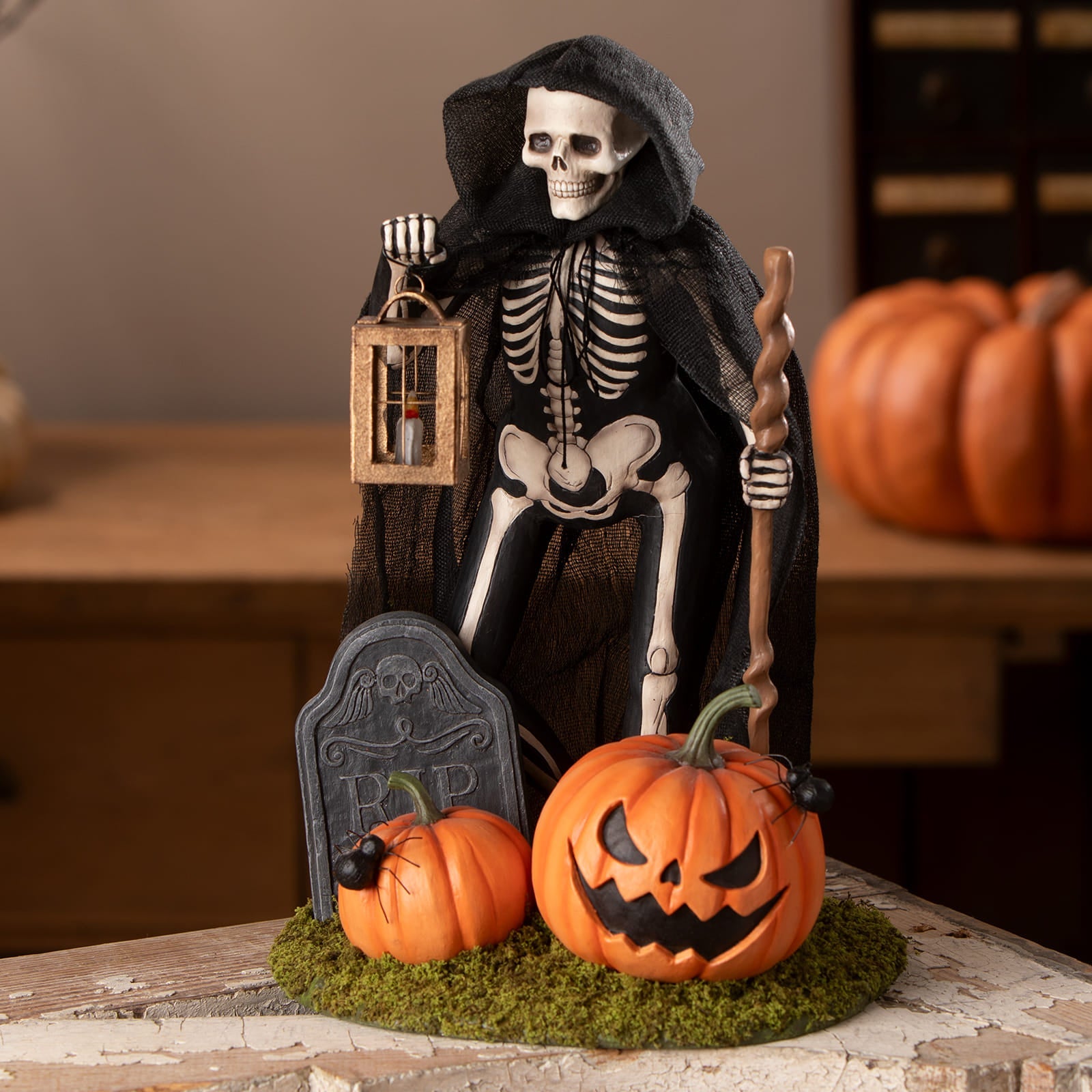 Graveyard gideon skeleton decor figure in black hooded cloak holding lantern and staff with pumpkins and tombstone base