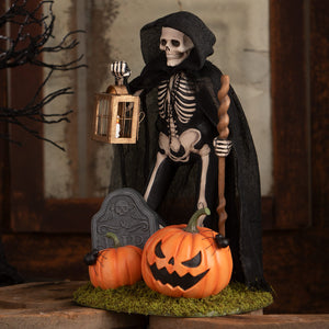 Graveyard gideon skeleton black cloaked skeleton decor figure holding lantern and staff beside carved pumpkins on mossy base